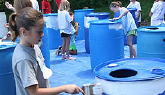 child painting rain barrel